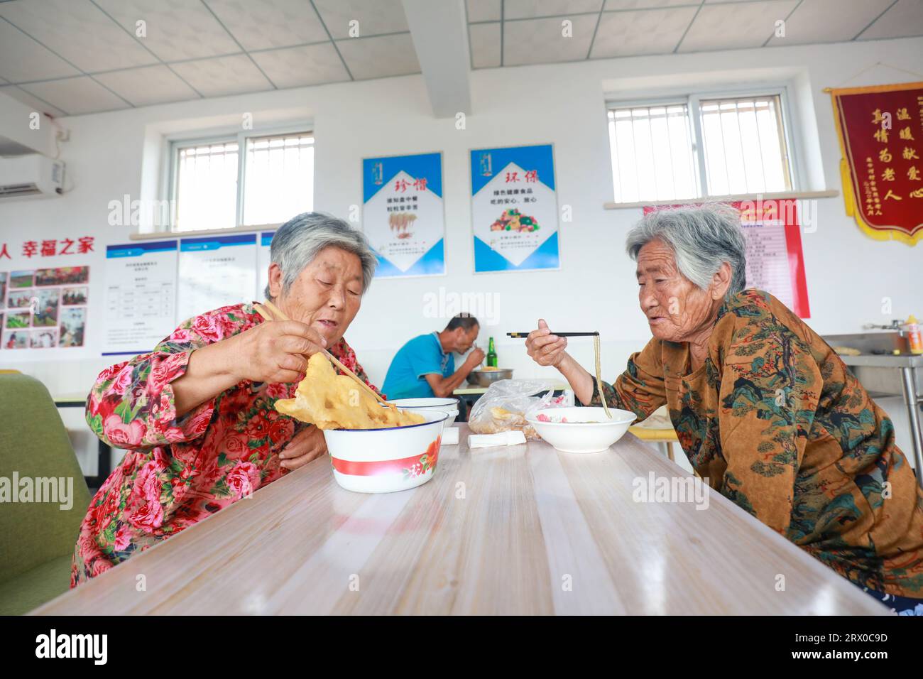 Contea di Luannan, Cina - 9 agosto 2023: Gli anziani che vivono da soli mangiano in piccole mense nelle aree rurali della Cina settentrionale. Foto Stock