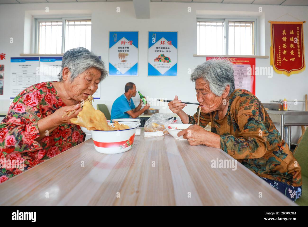Contea di Luannan, Cina - 9 agosto 2023: Gli anziani che vivono da soli mangiano in piccole mense nelle aree rurali della Cina settentrionale. Foto Stock