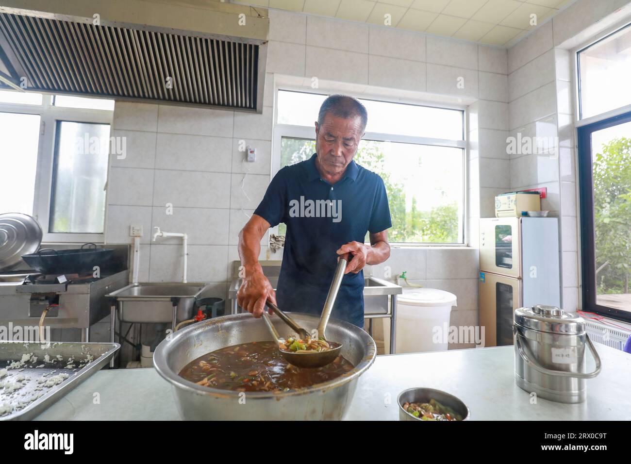 Contea di Luannan, Cina - 9 agosto 2023: Il personale serve pasti agli anziani che vivono da soli, un buon modo per servire i loro pasti. Foto Stock