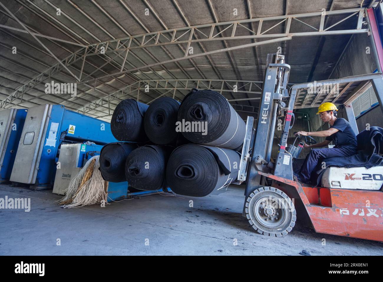 Contea di Luannan, Cina - 24 agosto 2022: I lavoratori guidano carrelli elevatori per trasportare prodotti non tessuti. Foto Stock