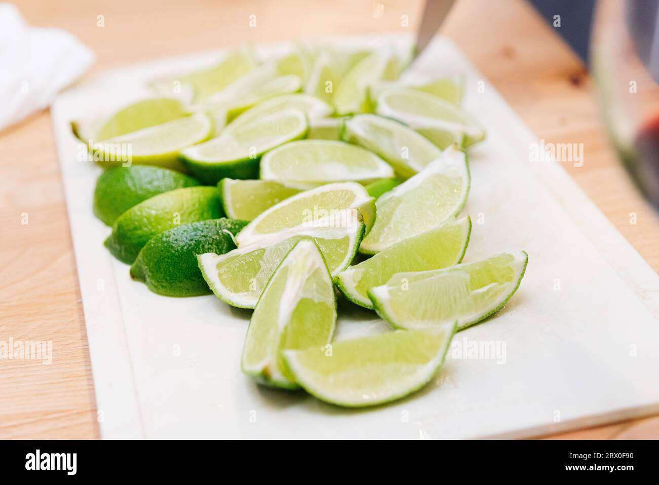 Fette di lime su un tagliere nella cucina di un ristorante. Spicchi di lime. Foto Stock