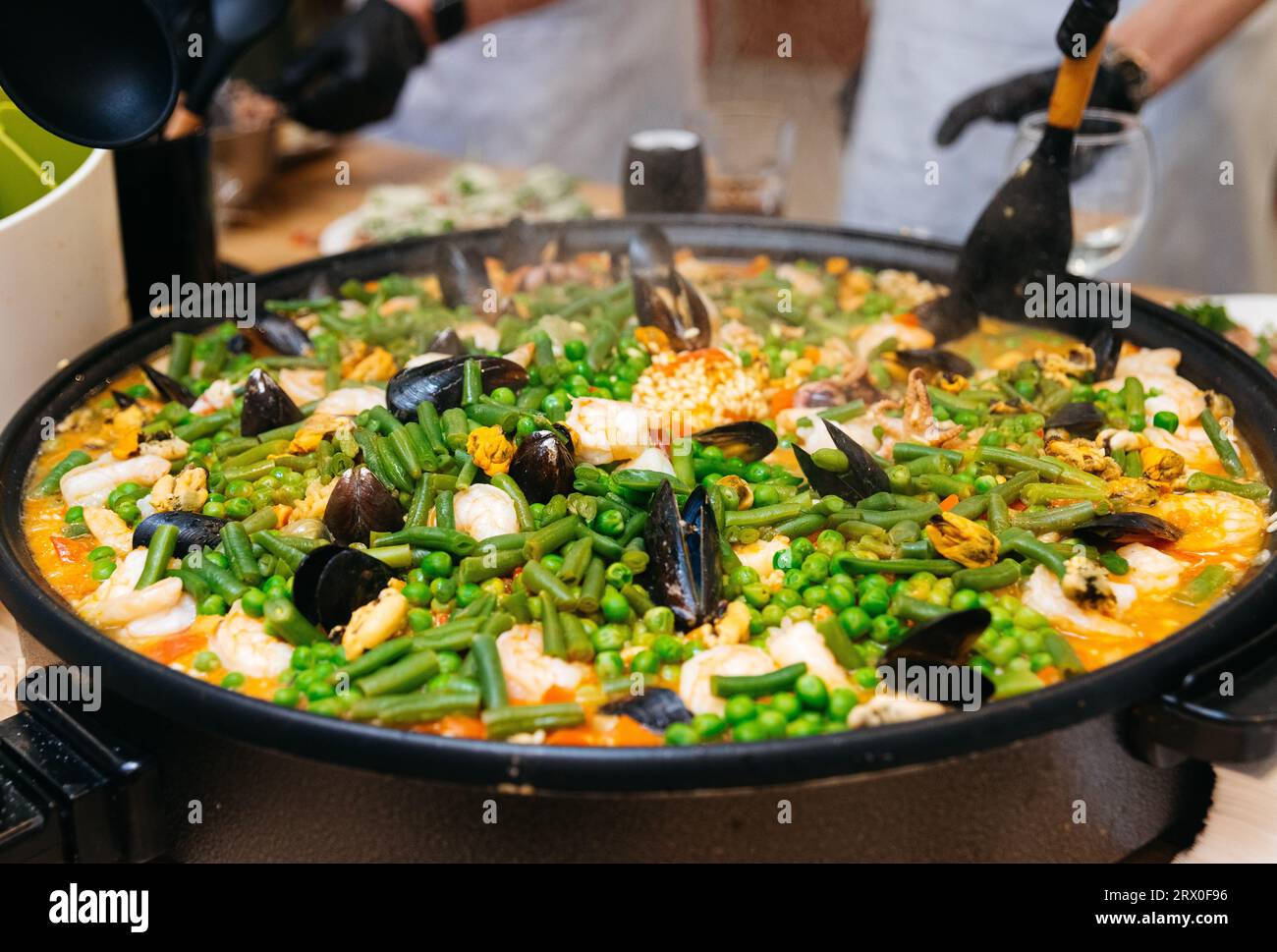 cucina di paella con frutti di mare e verdure in una master class culinaria. cottura a vapore in paella grande. Foto Stock