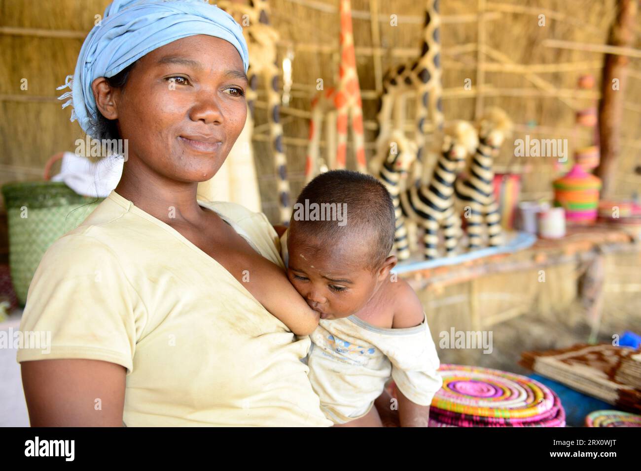 Una donna malgascia che allatta il suo bambino. Foto scattata nel Madagascar centrale. Foto Stock