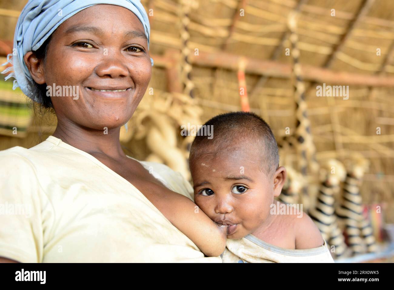 Una donna malgascia che allatta il suo bambino. Foto scattata nel Madagascar centrale. Foto Stock