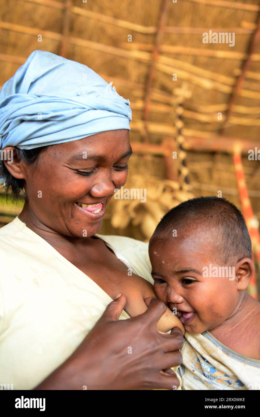 Una donna malgascia che allatta il suo bambino. Foto scattata nel Madagascar centrale. Foto Stock
