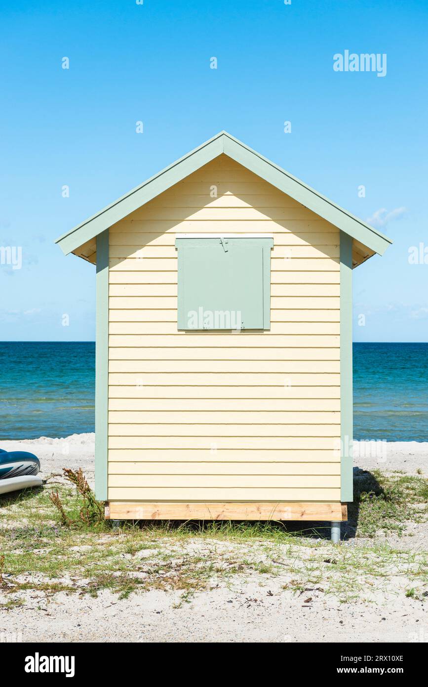 Vista frontale sul retro di una baita in legno giallo sulla spiaggia di Skanör med Falsterbo al Öresund al sole del mattino, Skåne, Svezia Foto Stock