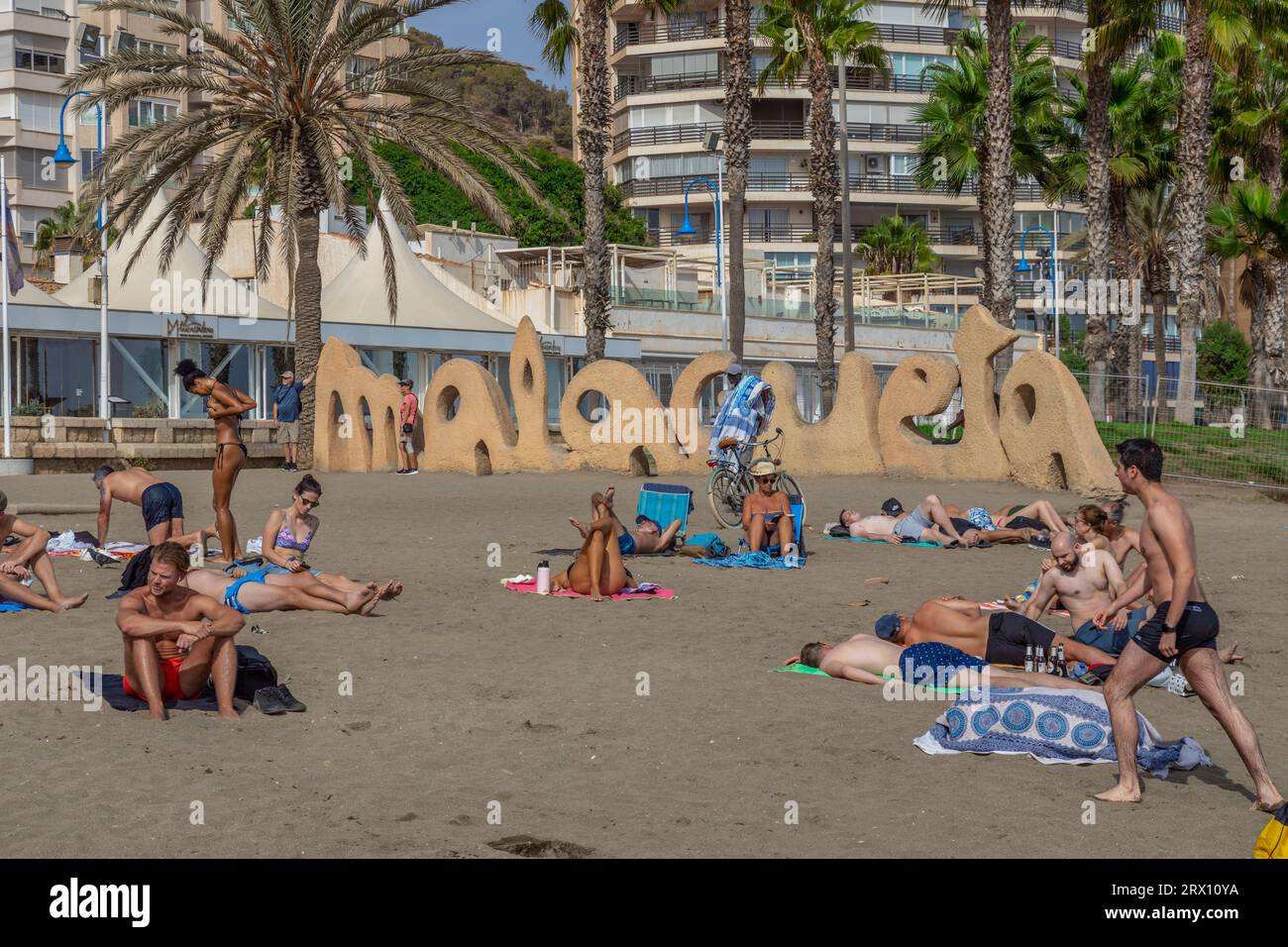 Spiaggia di Malagueta a Malaga alla luce del sole autunnale. Cielo blu sopra. Gente che prende il sole sotto il cielo blu della costa del sol. Foto Stock