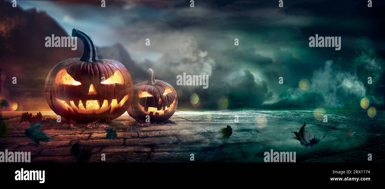 Zucche di Halloween in Una notte spettrale con effetti di luce e fumo astratti defocalizzati Foto Stock