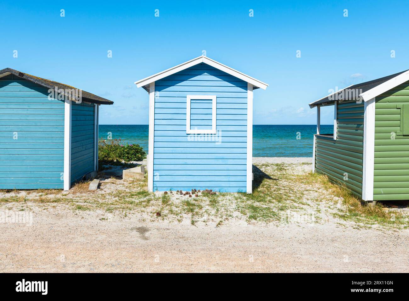 Colorate capanne in legno battute dal vento nelle dune di sabbia sulla spiaggia di Skanör med Falsterbo sul Öresund al sole del mattino, Skåne, Svezia Foto Stock