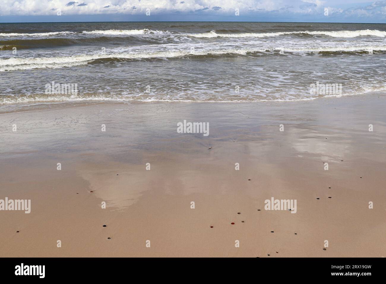 Cielo blu e nuvole bianche riflesse nella sabbia bagnata della spiaggia Foto Stock