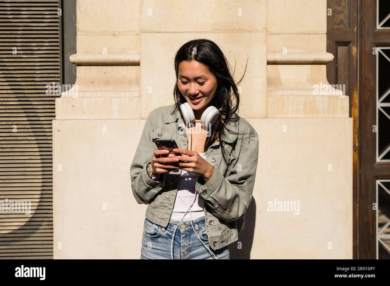 Bella ragazza che usa il suo smartphone per strada. Foto Stock