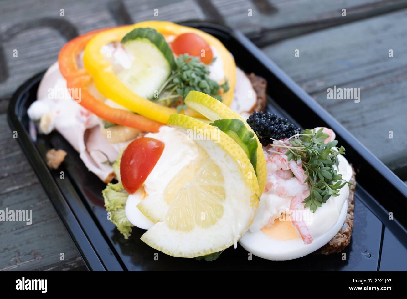 Panini aperti da un supermercato di Billund, Danimarca. Pane di segale con uovo, maionese, gamberi, crescione, limone davanti e prosciutto, fette di pepe, t Foto Stock