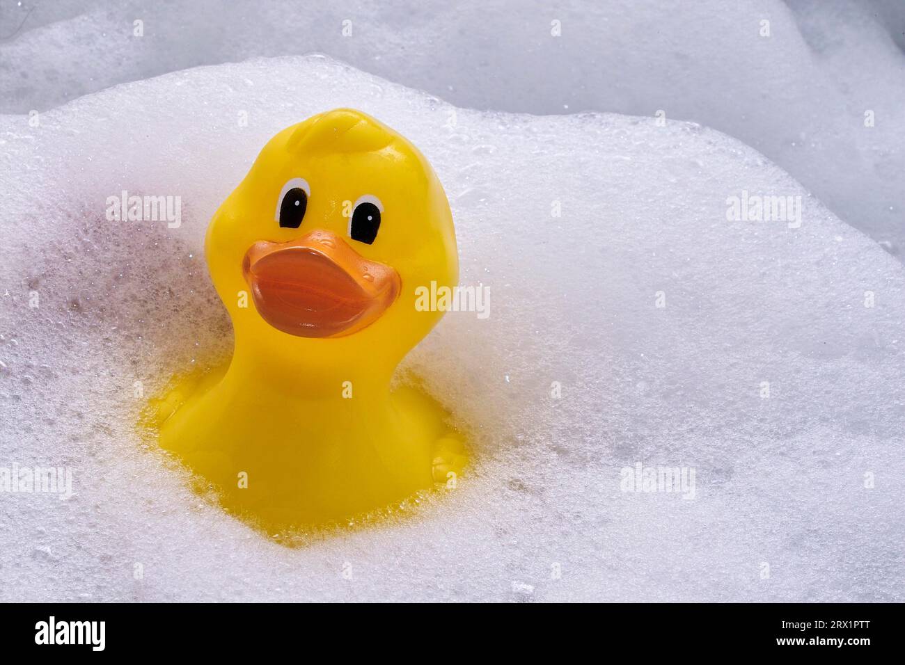 Immergiti nel bagno circondato da schiuma Foto Stock