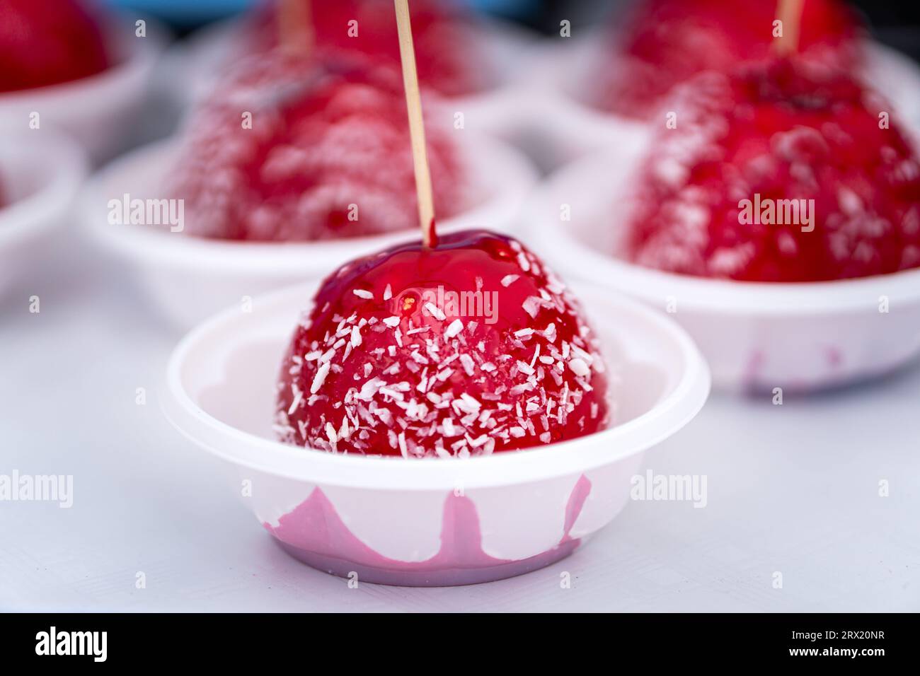 Dessert di mele ricoperte di caramello rosso con patatine di cocco. Amo Apple. Foto Stock
