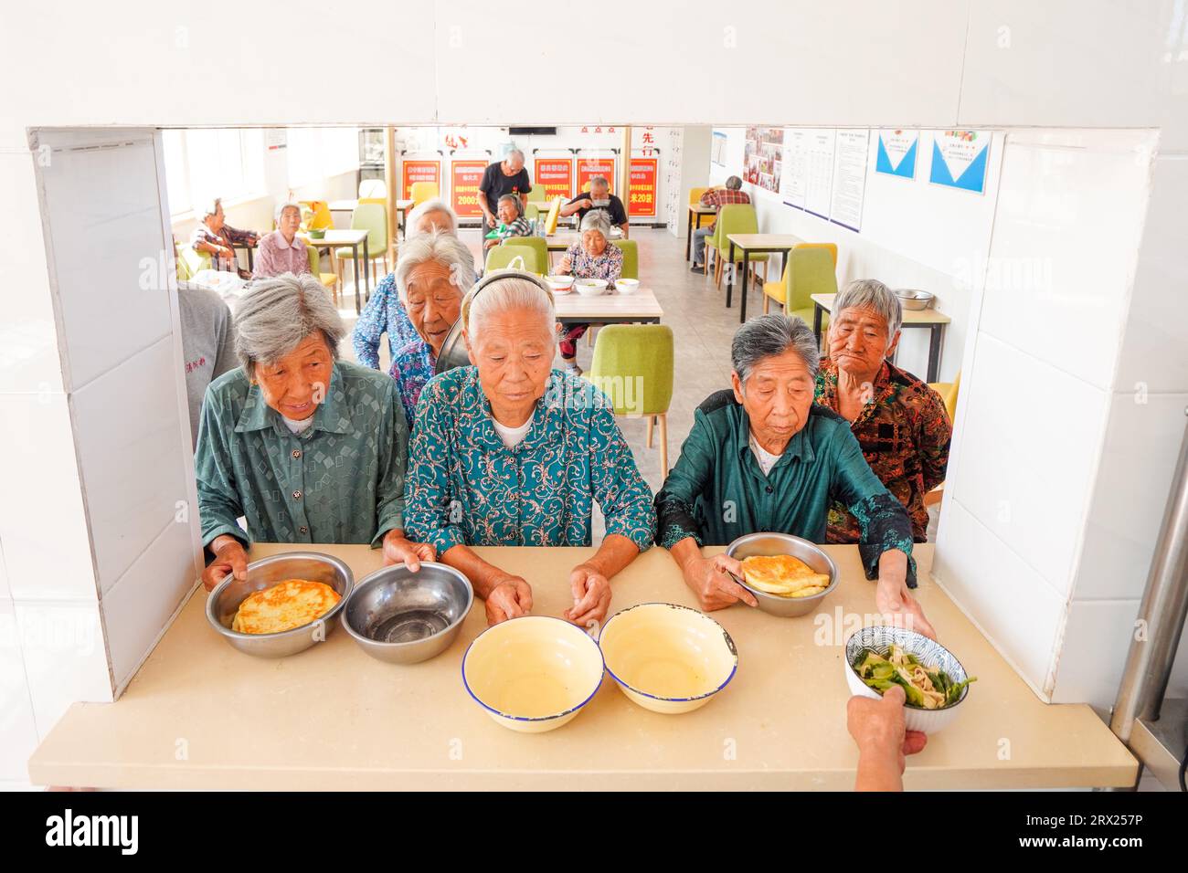 Contea di Luannan, Cina - 6 settembre 2022: Gli anziani che vivono da soli aspettano la cena in una piccola caffetteria. Foto Stock