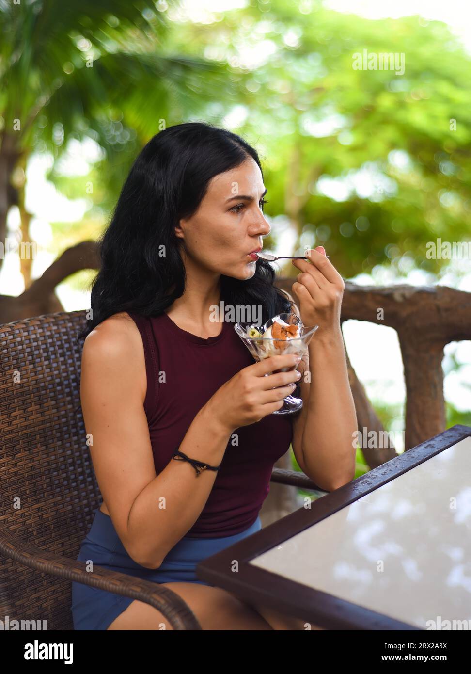 Bruna Ucraina donna di 37 anni che mangia un gelato e guarda un lato Foto Stock