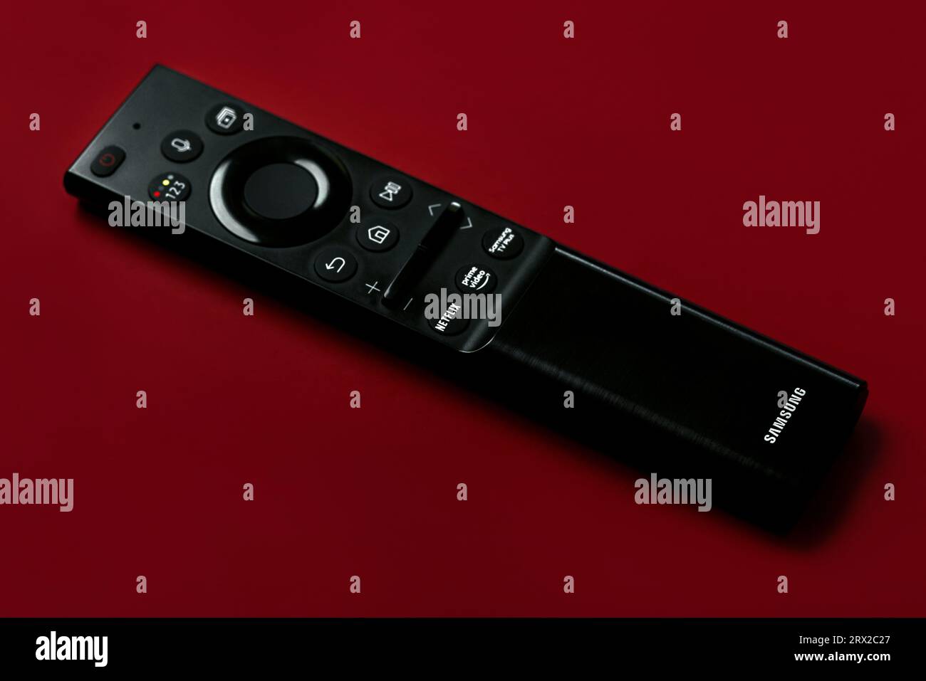 Primo piano del telecomando Samsung Smart TV con pulsanti per accedere ad Amazon prime e Netflix su sfondo rosso Foto Stock