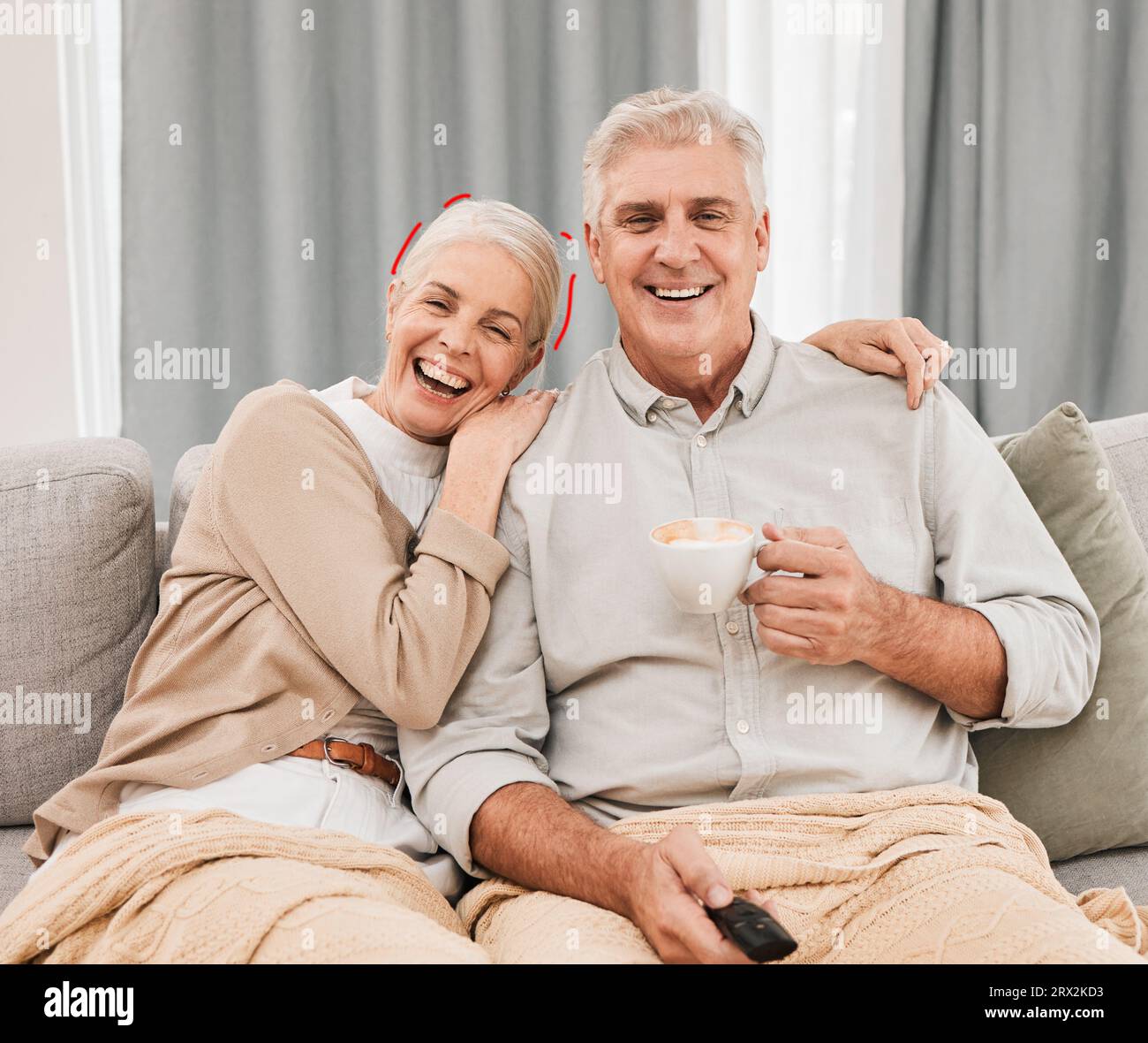 Coppia anziana che guarda la tv e ride sul divano del soggiorno con tè e film a casa. Anziani, legame e matrimonio in pensione con Foto Stock
