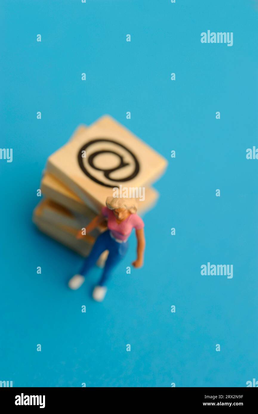 statuetta in miniatura donna e simbolo della posta elettronica Foto Stock