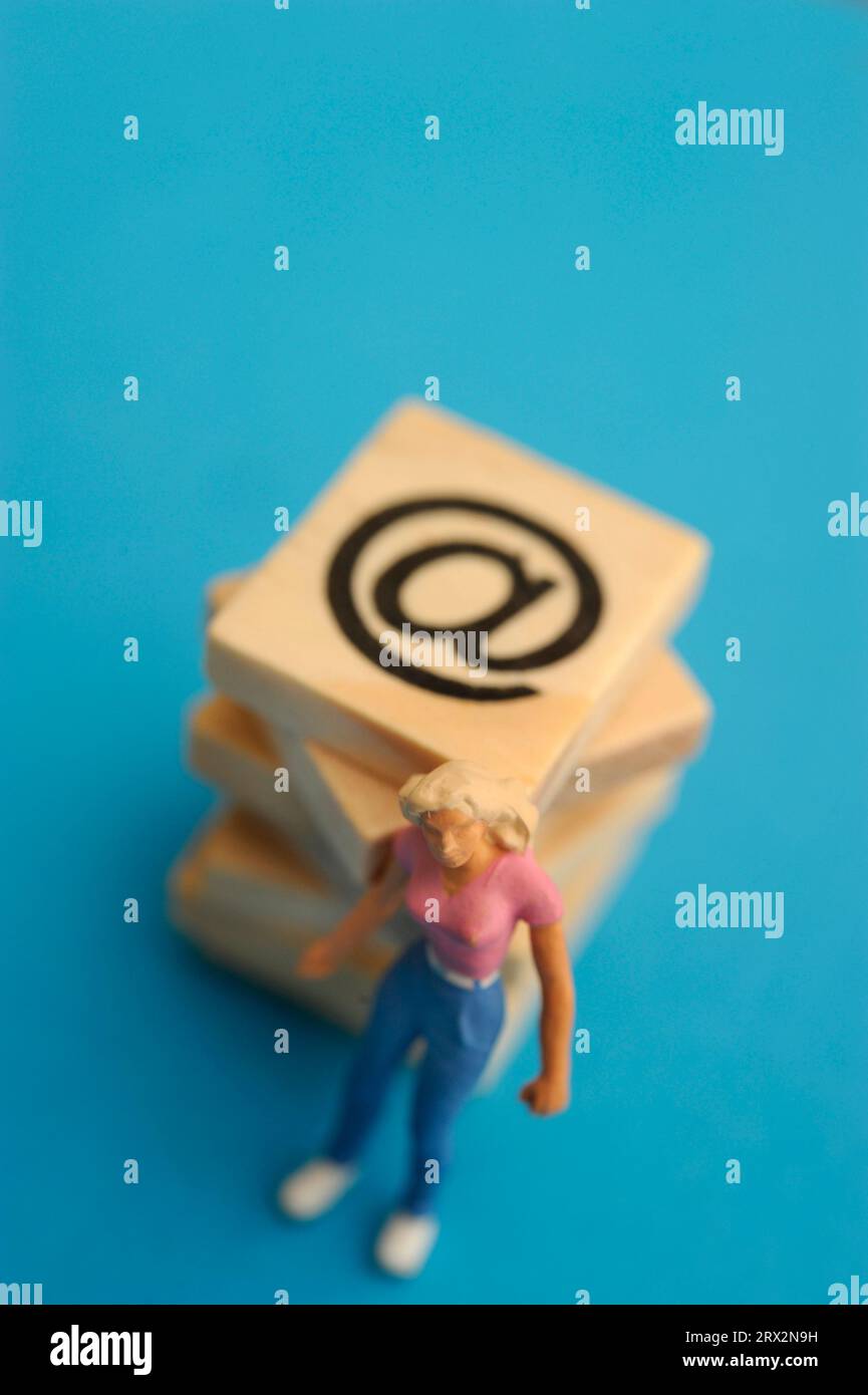 statuetta in miniatura donna e simbolo della posta elettronica Foto Stock