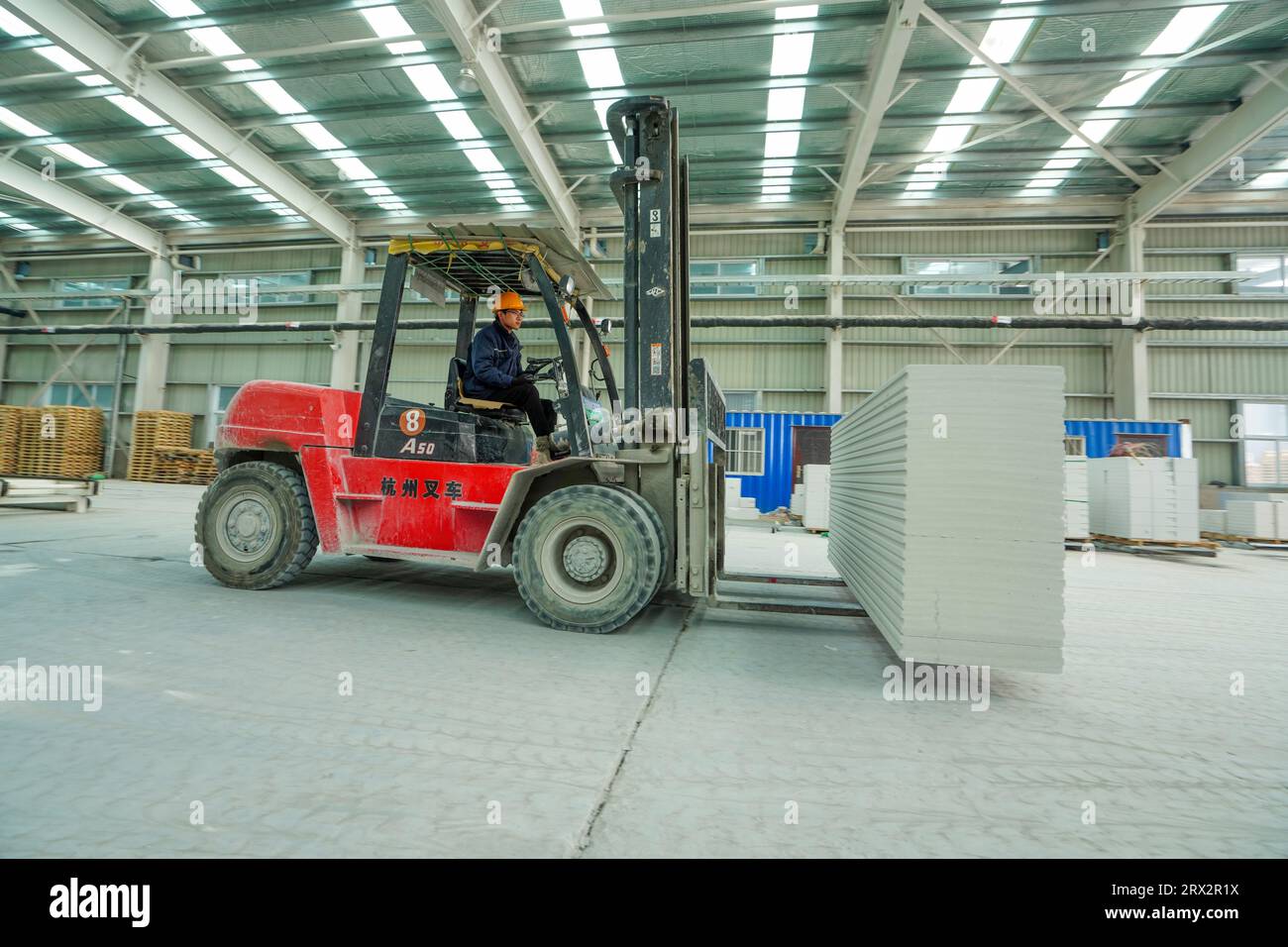 Contea di Luannan, Cina - 13 ottobre 2022: I lavoratori trasportano nuovi materiali edili con carrelli elevatori a forche - pannelli divisori leggeri, contea di Luannan, Hebe Foto Stock