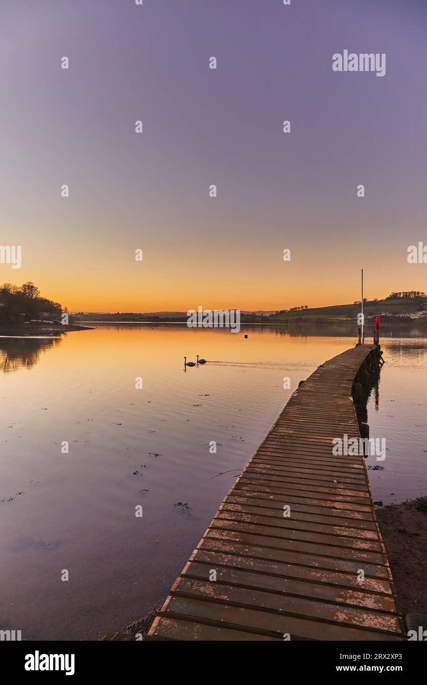 Una scena molto tranquilla al crepuscolo, con un molo di legno sull'estuario del fiume Teign, a Coombe Cellars, vicino Newton Abbot, costa meridionale del Devon, Inghilterra Foto Stock