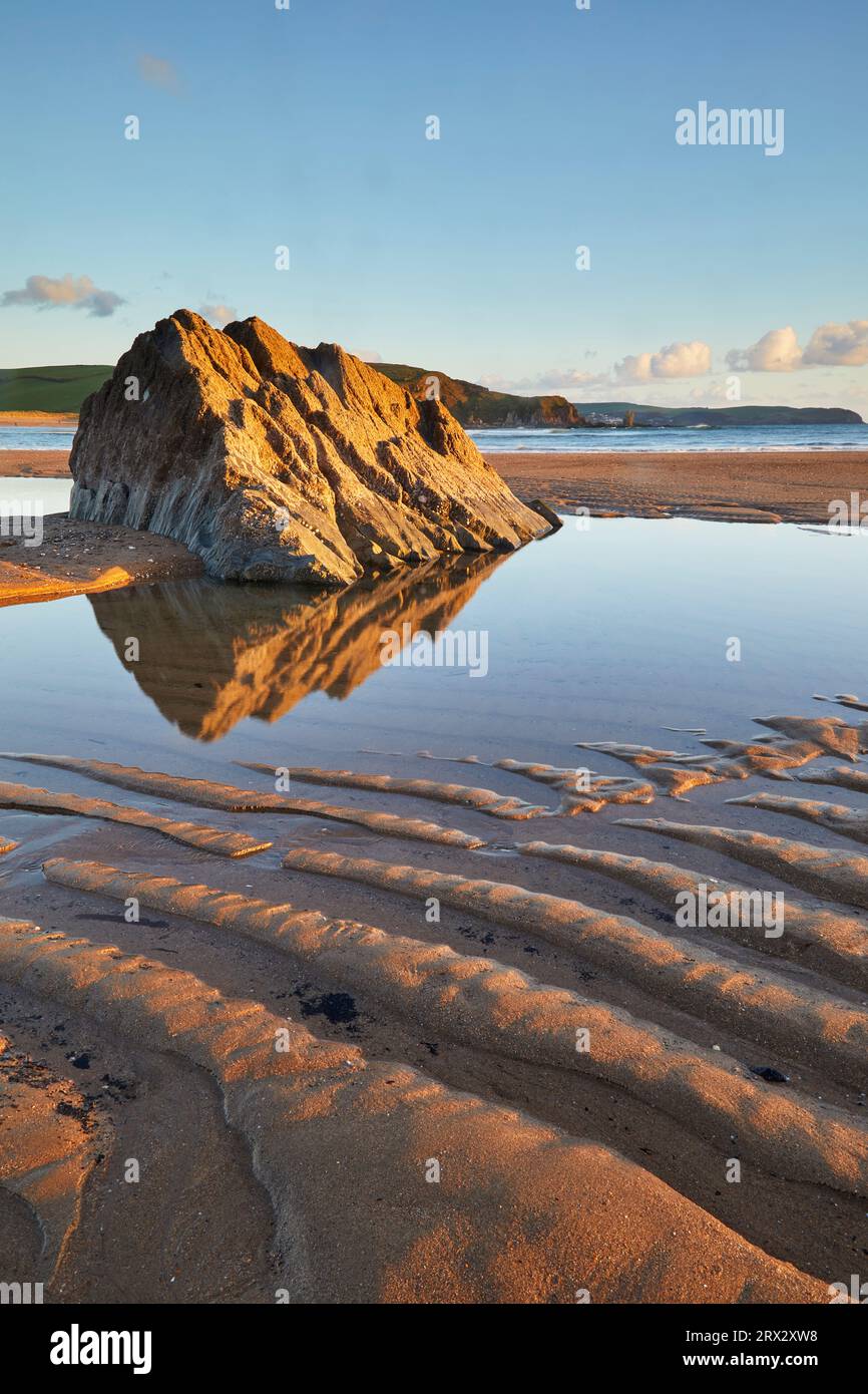 Una piscina di roccia e sabbia ondulata, sulla spiaggia con la bassa marea, a Bigbury-on-Sea, costa meridionale di Devon, Inghilterra, Regno Unito, Europa Foto Stock