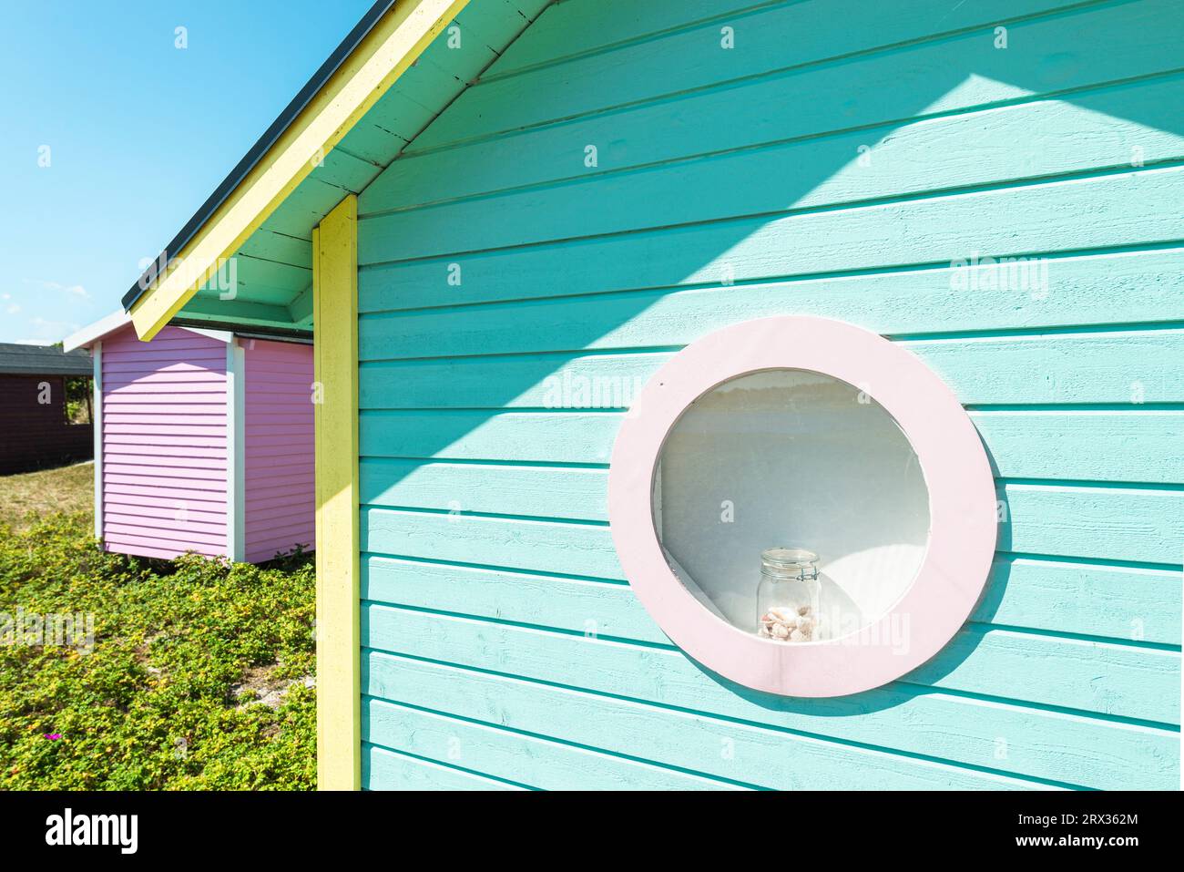 Vetro con conchiglie nella finestra rotonda di una capanna da bagno blu-verde nelle dune di sabbia sulla spiaggia di Skanör med Falsterbo, Skåne, Svezia Foto Stock