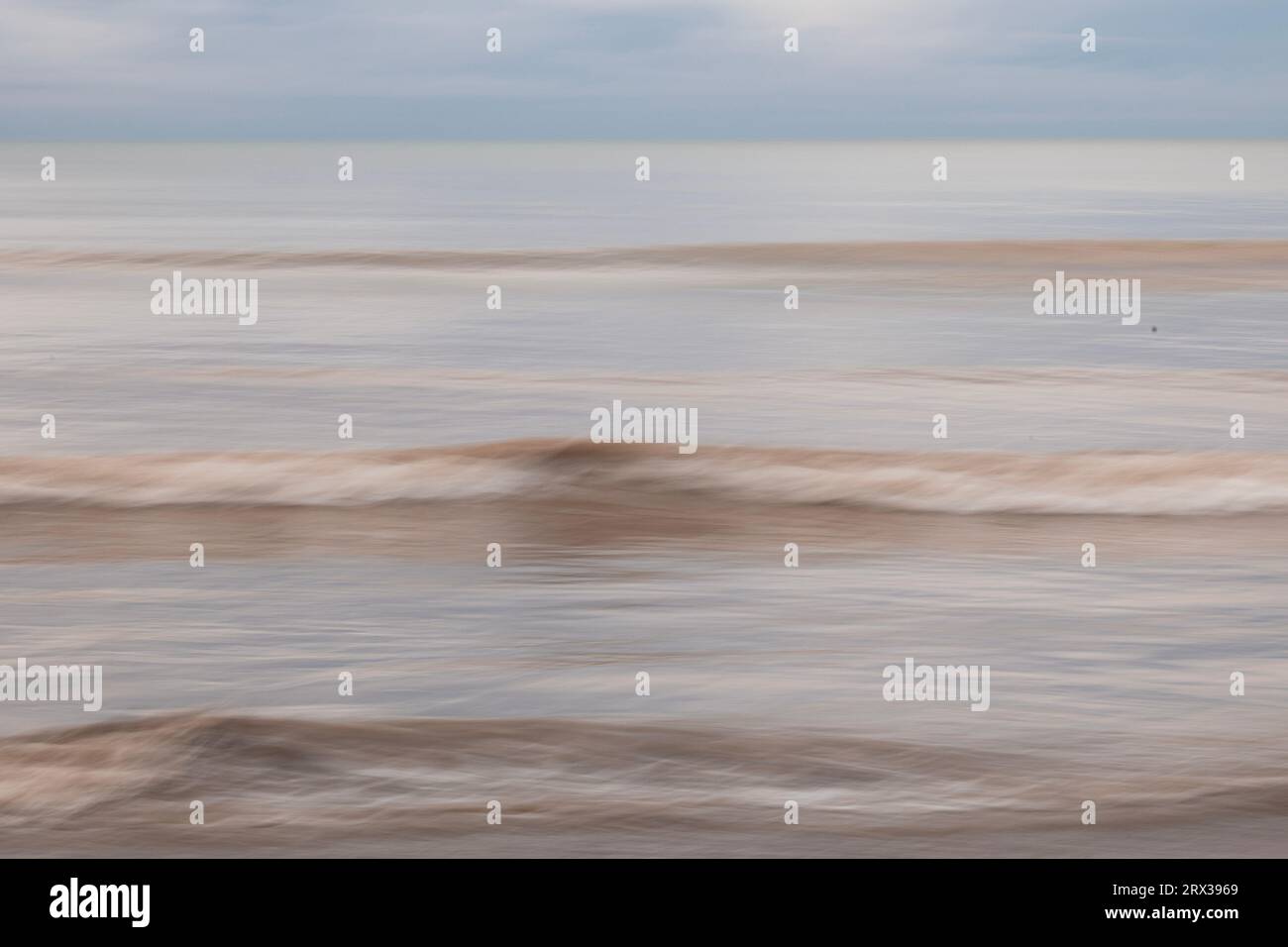 Movimento intenzionale di onde che si infrangono su una spiaggia a Worthing, West Sussex, Regno Unito Foto Stock