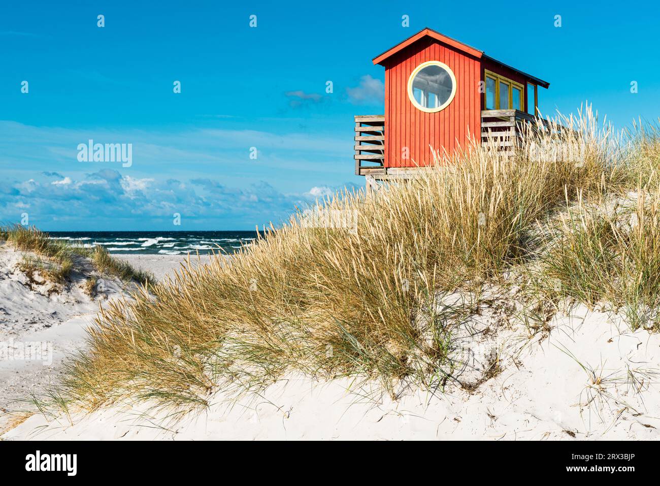 Torre di osservazione dei bagnini in legno rosso su palafitte presso il bar sulla spiaggia tra le dune di sabbia sulla spiaggia di Skanör med Falsterbo al sole del mattino, Skåne, Svezia Foto Stock