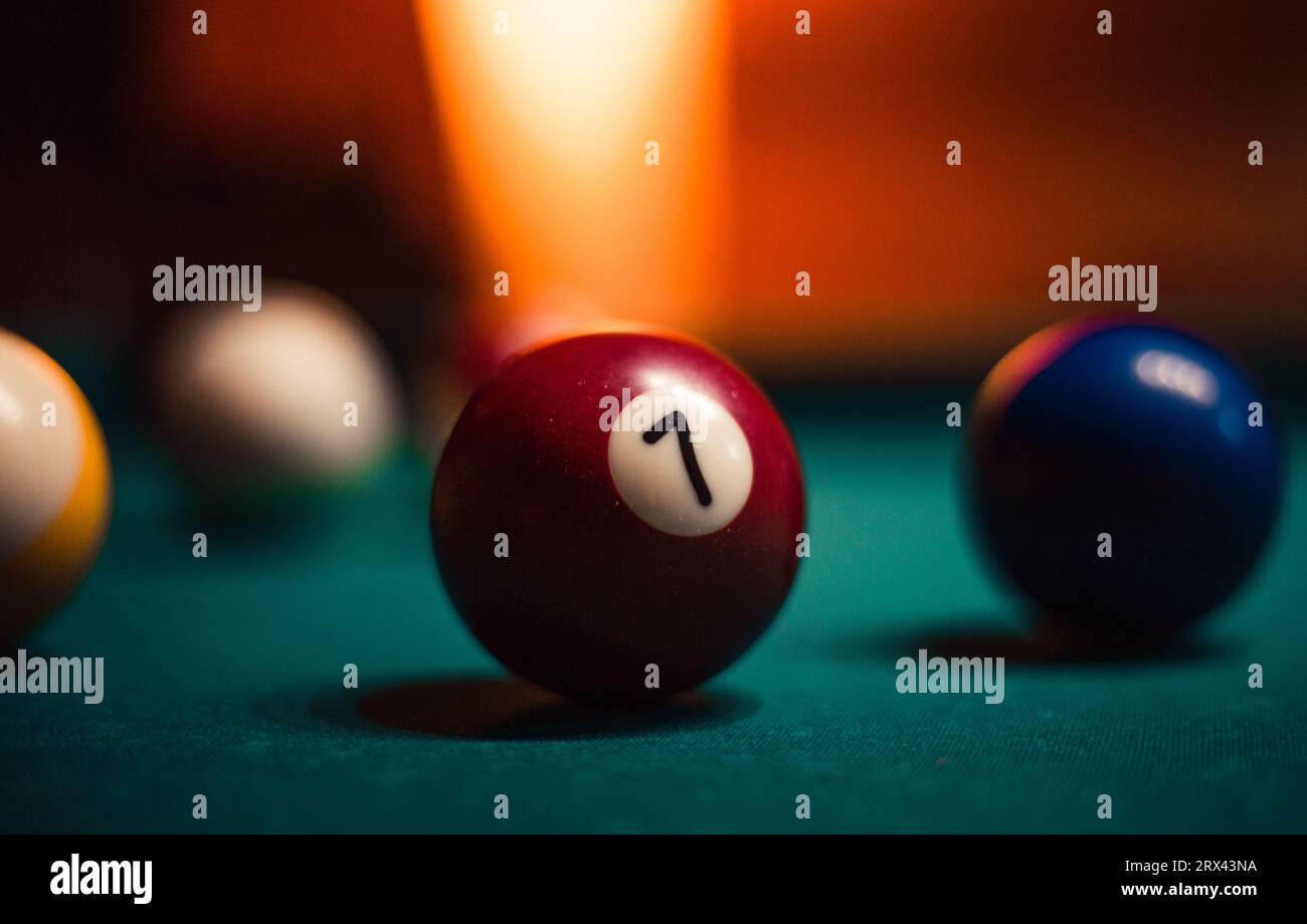 Foto dettagliata di palline da biliardo su un accogliente sfondo caldo con illuminazione arancione. Immagine ravvicinata di palline da biliardo colorate. Foto Stock