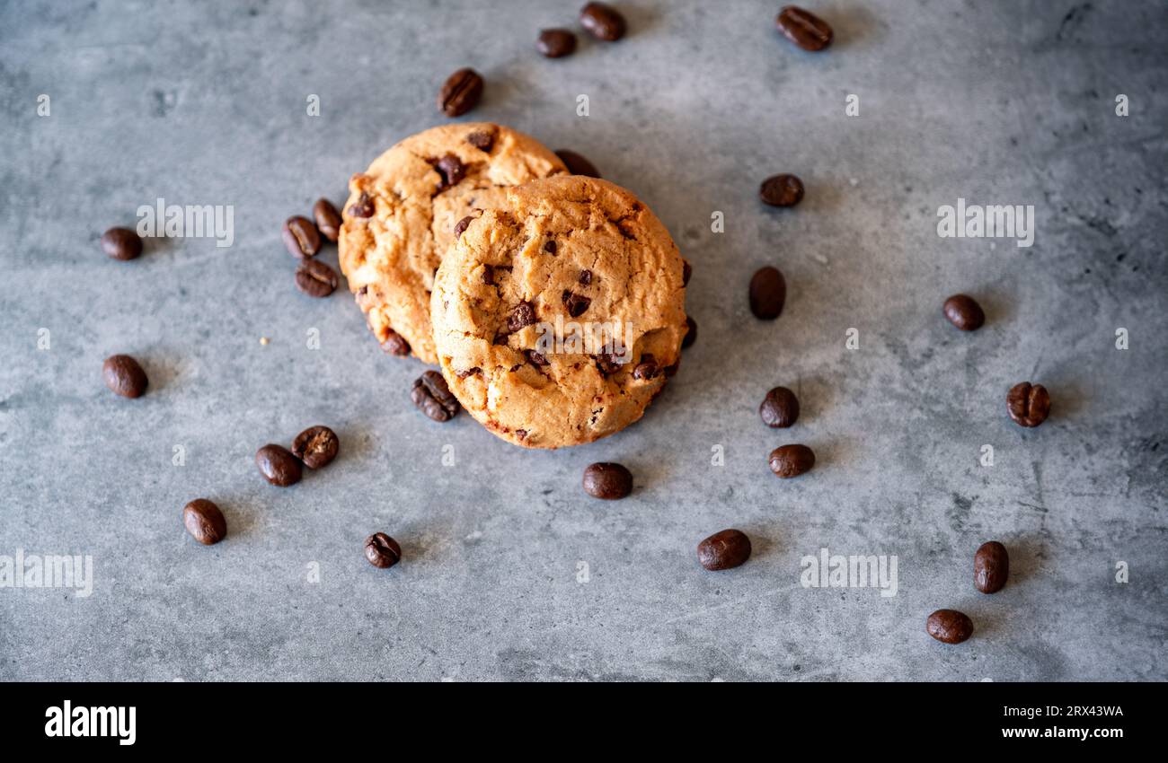 Due pezzi di biscotti con chicchi di caffè su sfondo grigio Foto Stock