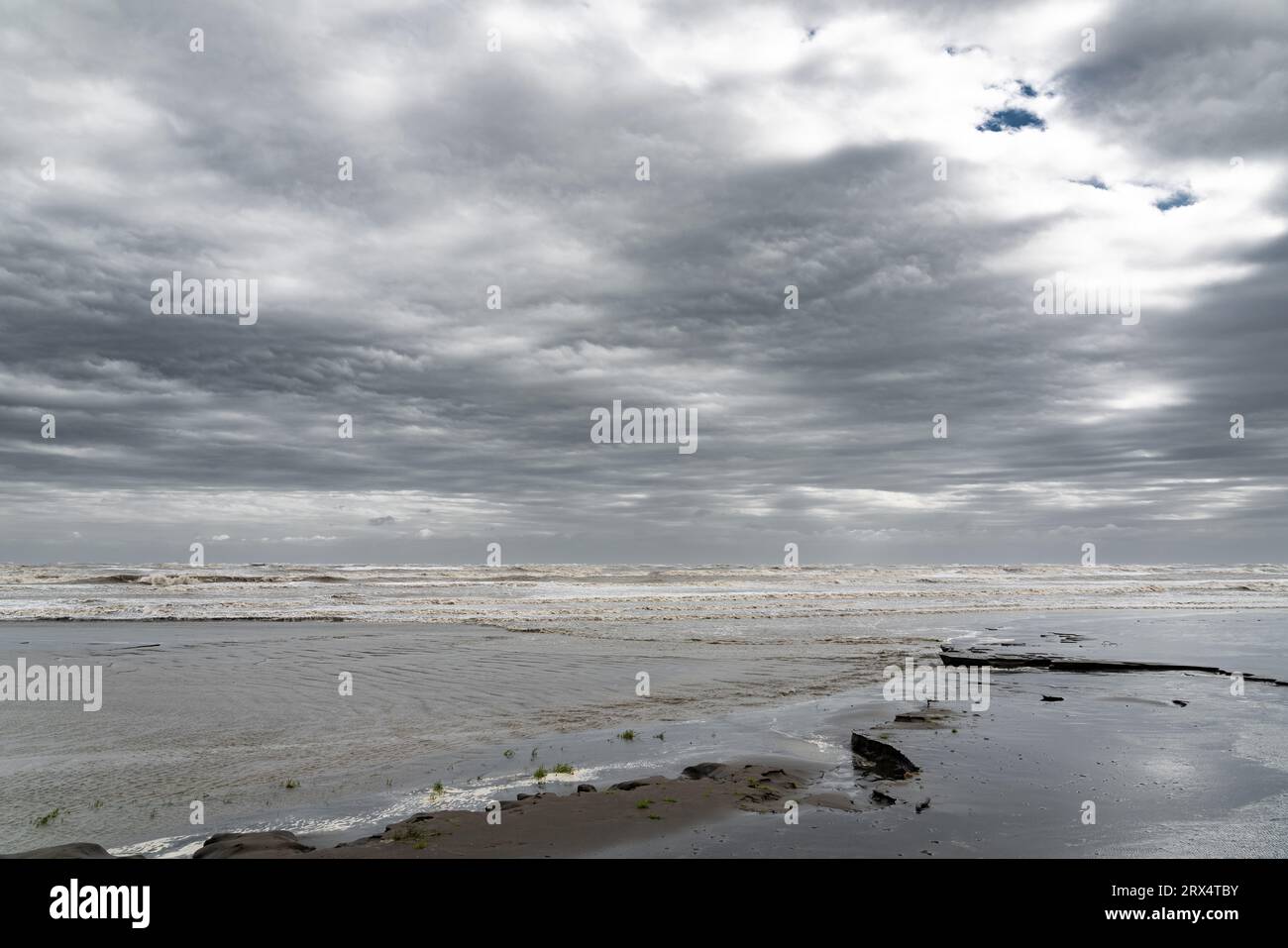 Spiaggia sabbiosa con nuvole di tuoni Foto Stock