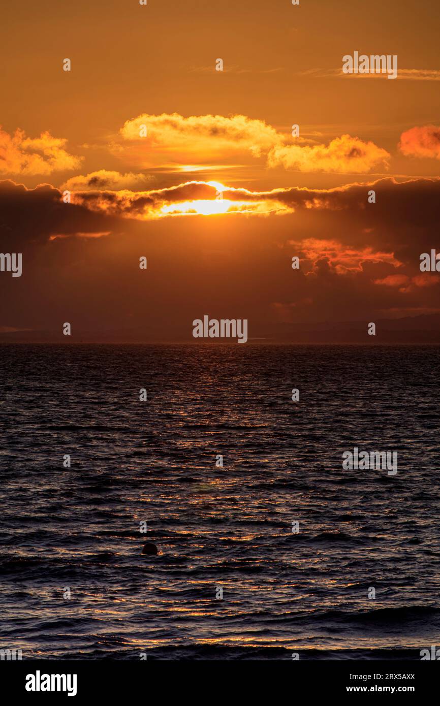 Il sole che tramonta illumina l'orizzonte appena prima che tramonti Foto Stock