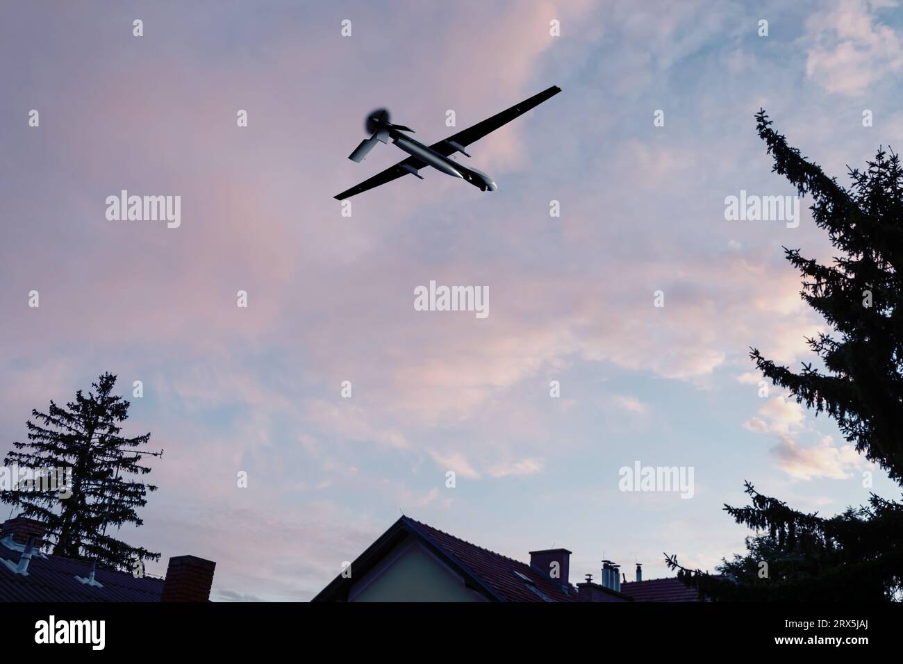 Drone militare senza equipaggio che vola nel cielo su edifici residenziali, equipaggiamento americano, concetto: Drone da ricognizione militare, drone att Foto Stock