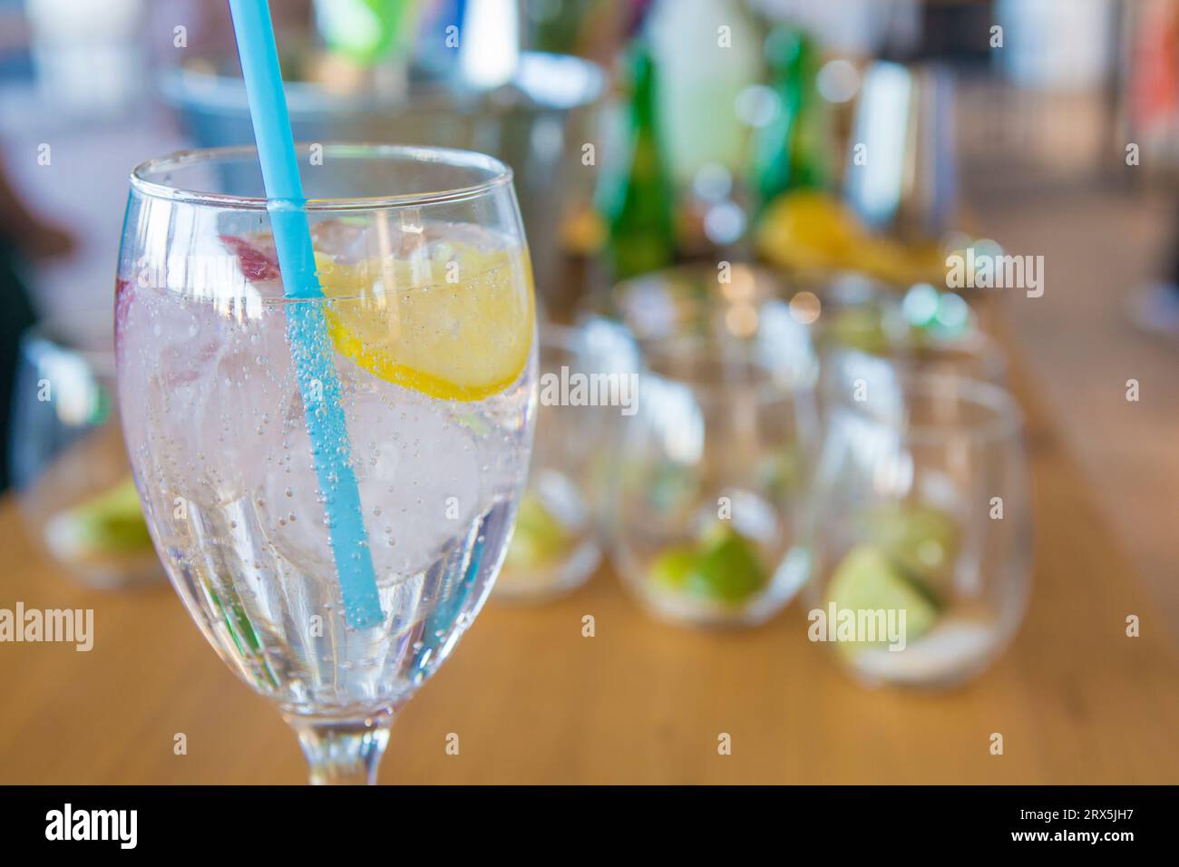 Cocktail rinfrescante con paglia blu. Cameriere che serve cocktail come sottofondo Foto Stock