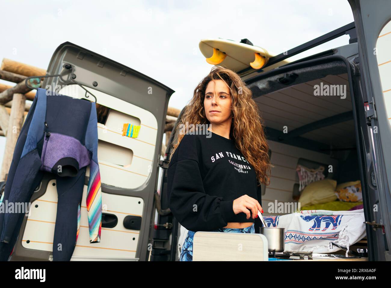 Donna premurosa che cucinava fuori camper in vacanza Foto Stock