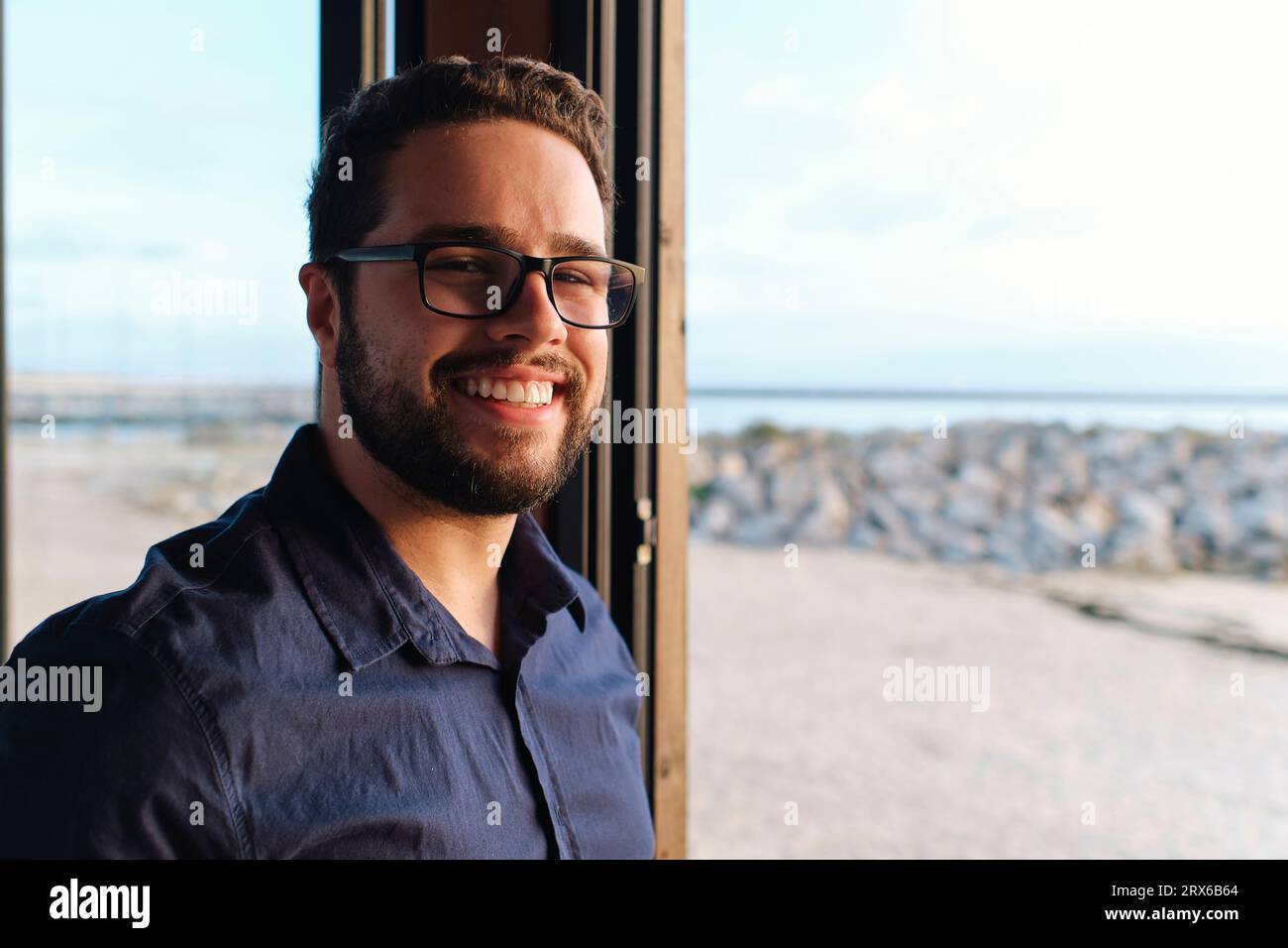 Giovane ingegnere felice che indossa occhiali da vista in caffetteria Foto Stock