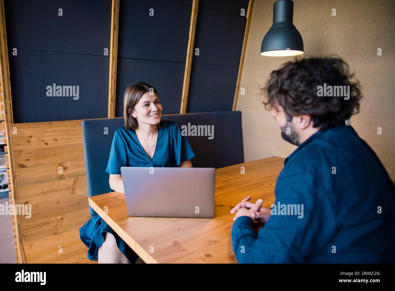 Sorridere gli uomini d'affari con un notebook che discutono in ufficio Foto Stock