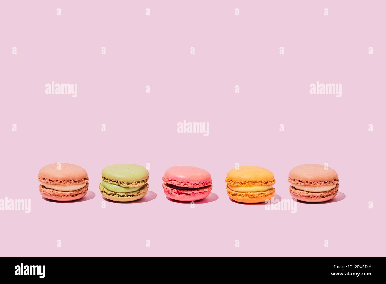 Macaron colorati su sfondo rosa Foto Stock