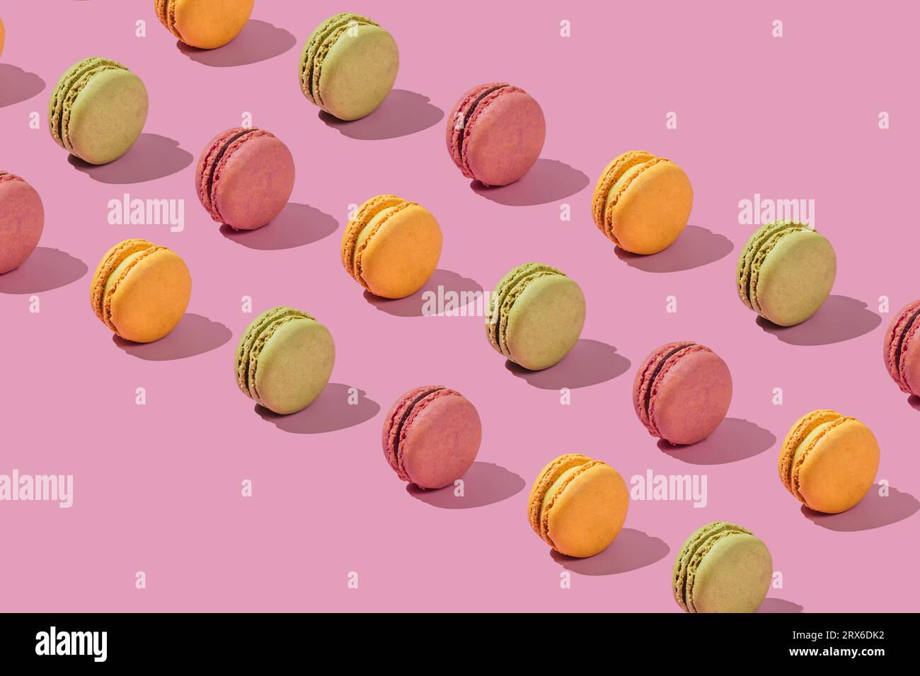 Macaron al forno disposti su sfondo rosa Foto Stock