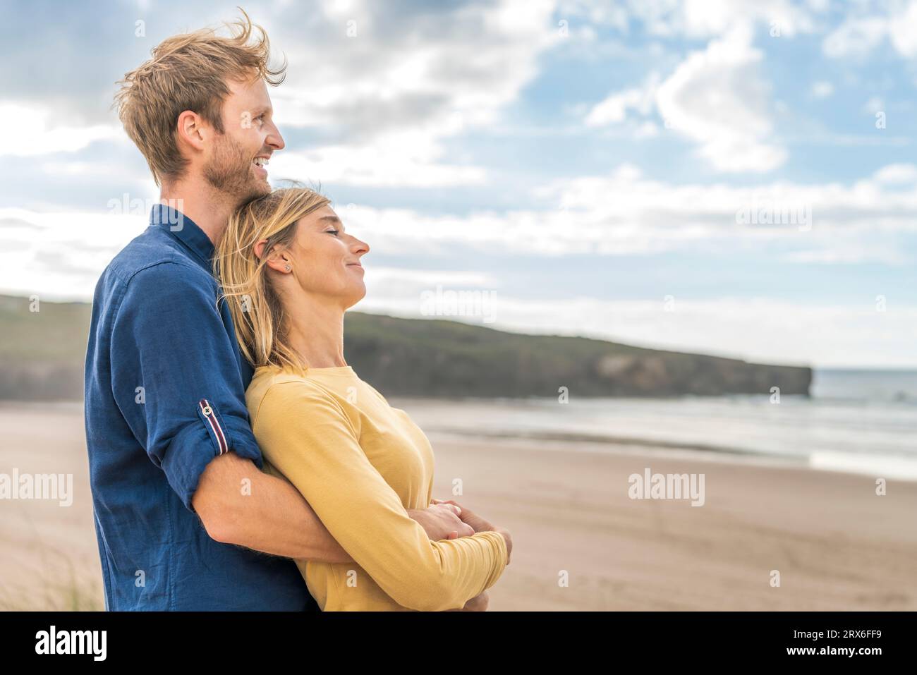 Un uomo felice in piedi con una donna in spiaggia Foto Stock