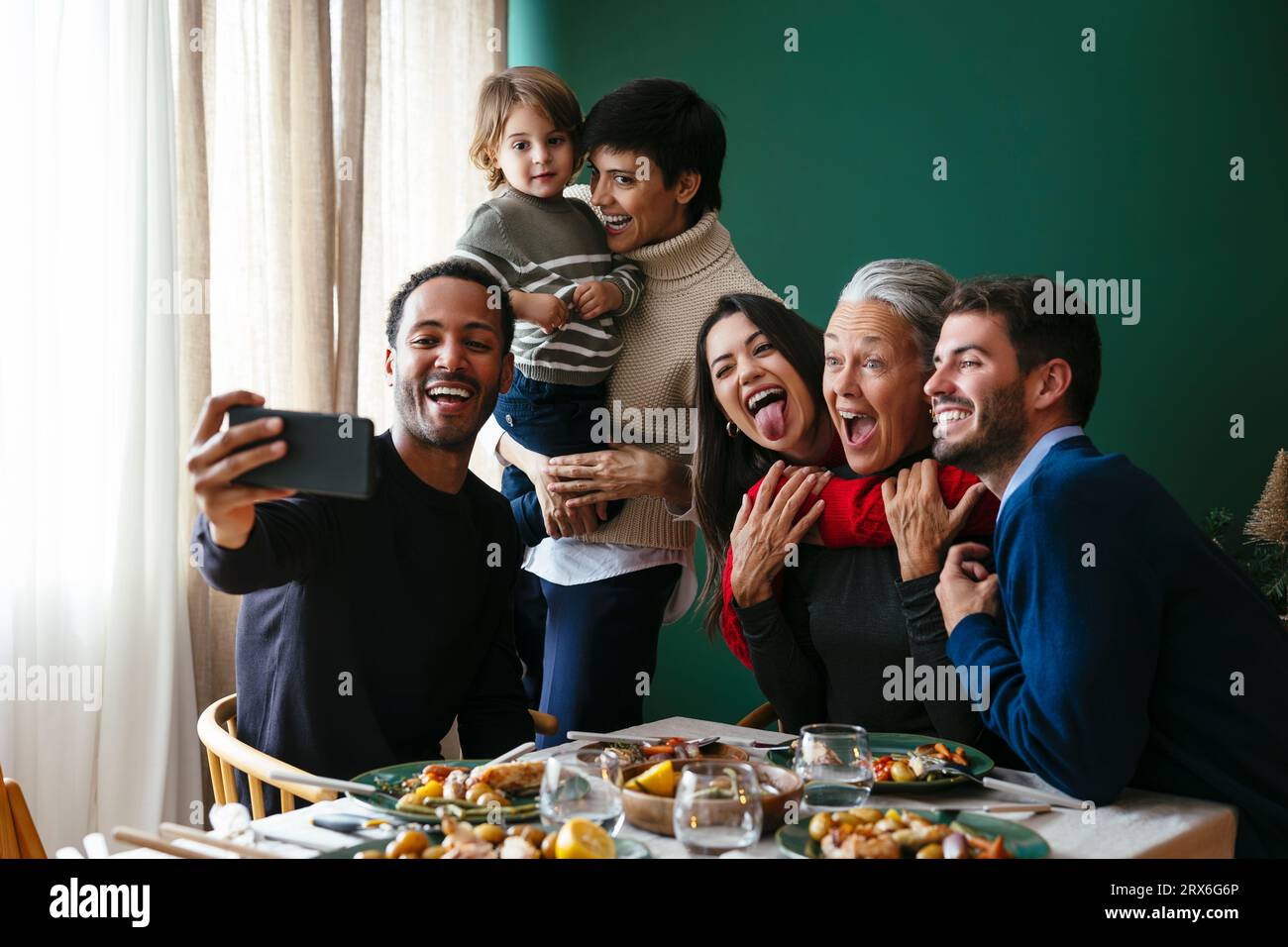 Felice famiglia multirazziale che scatta selfie con lo smartphone a casa a Natale Foto Stock