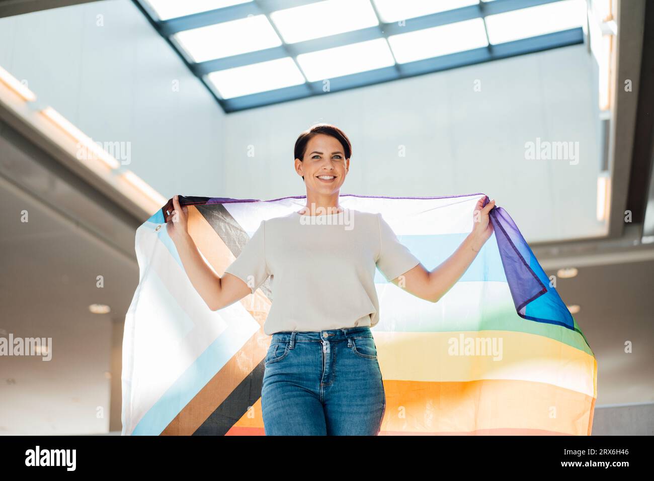 Donna d'affari sorridente con sciarpa colorata sul posto di lavoro Foto Stock