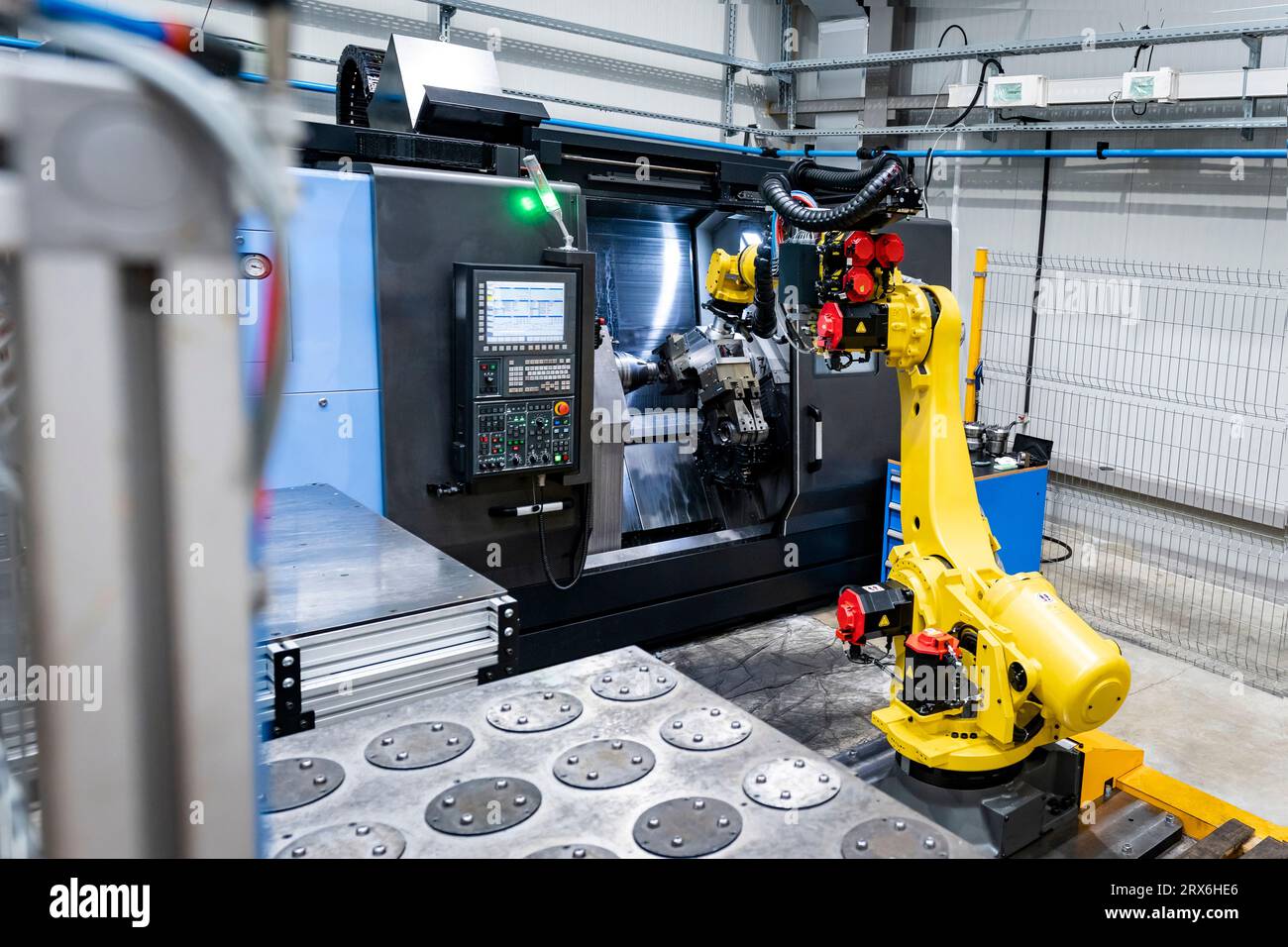 Braccio robotico giallo con macchinari in fabbrica Foto Stock