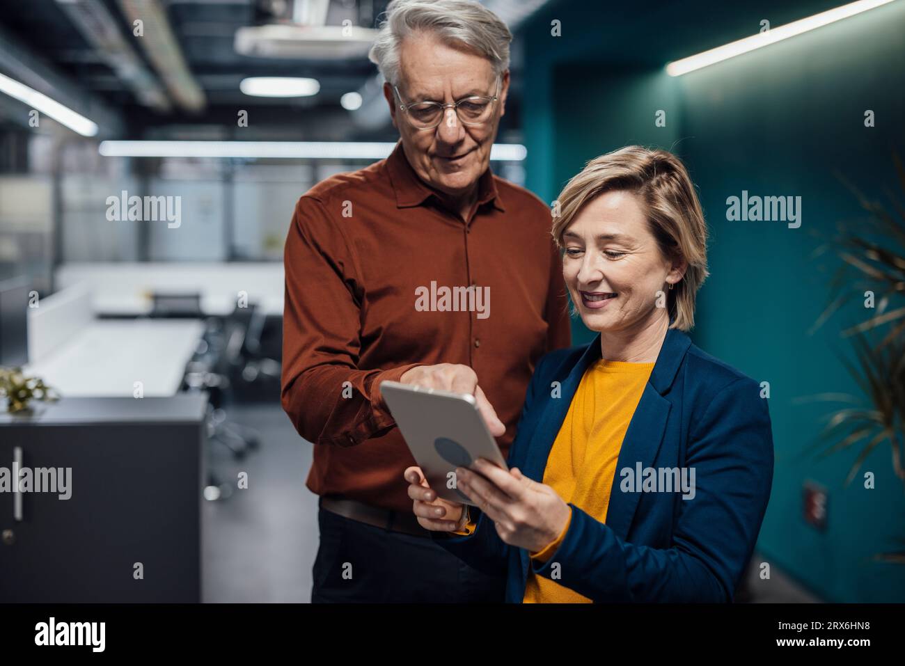 Colleghi di lavoro che discutono sul PC tablet sul posto di lavoro Foto Stock