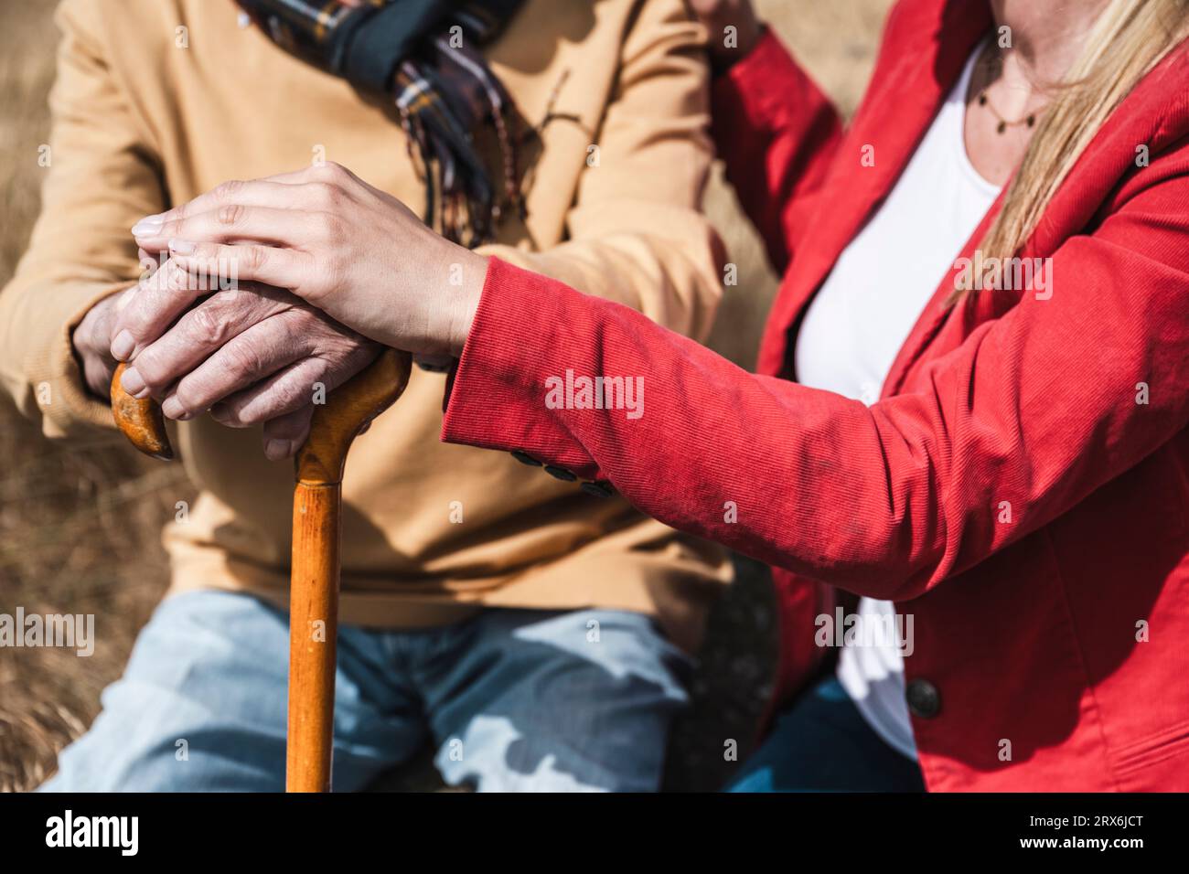 Donna che si stacca la mano su un bastone nelle giornate di sole Foto Stock