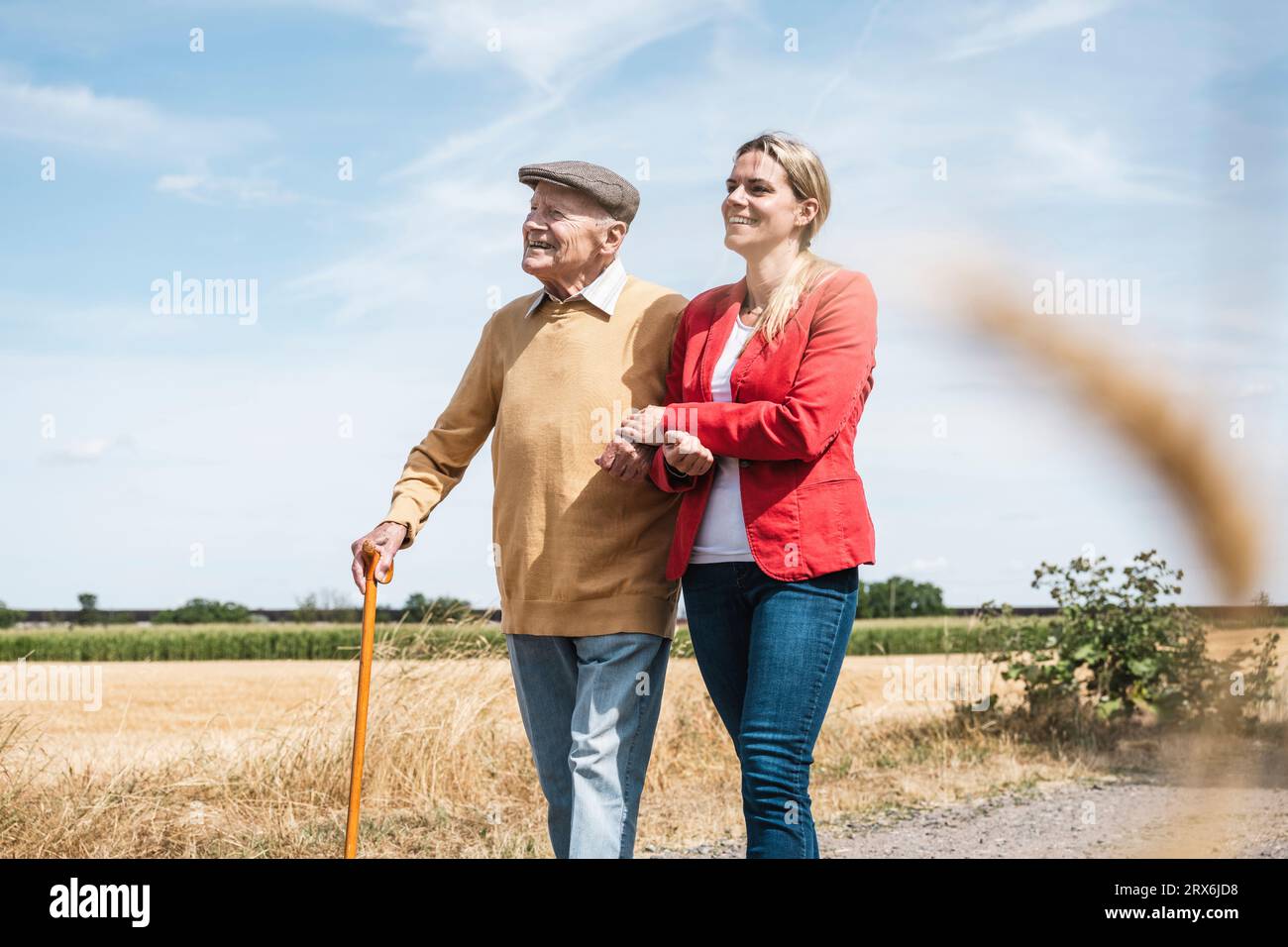 Donna felice che tiene per mano un uomo anziano nelle giornate di sole Foto Stock