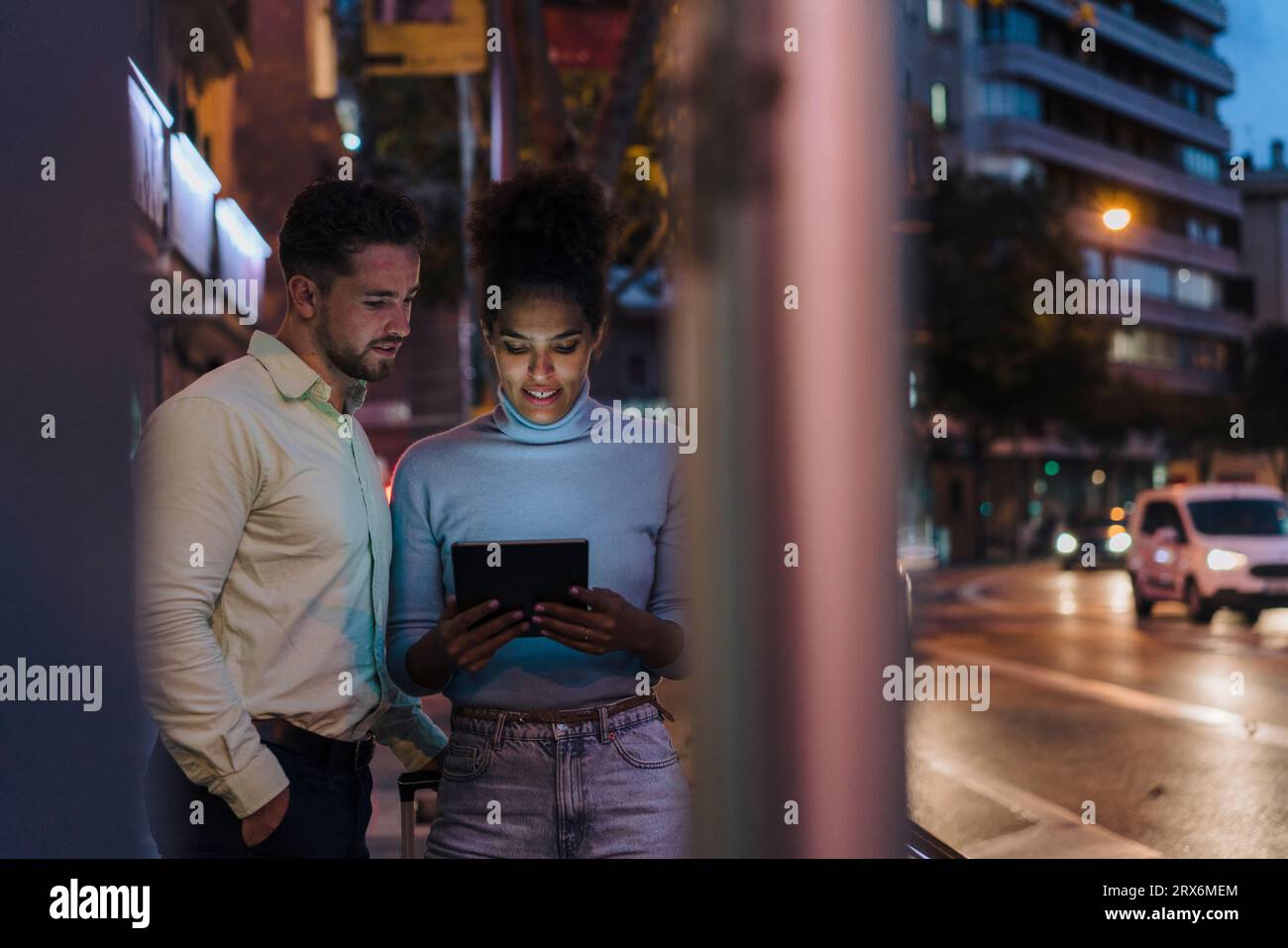 Uomo d'affari con un collega che usa un tablet PC per strada Foto Stock