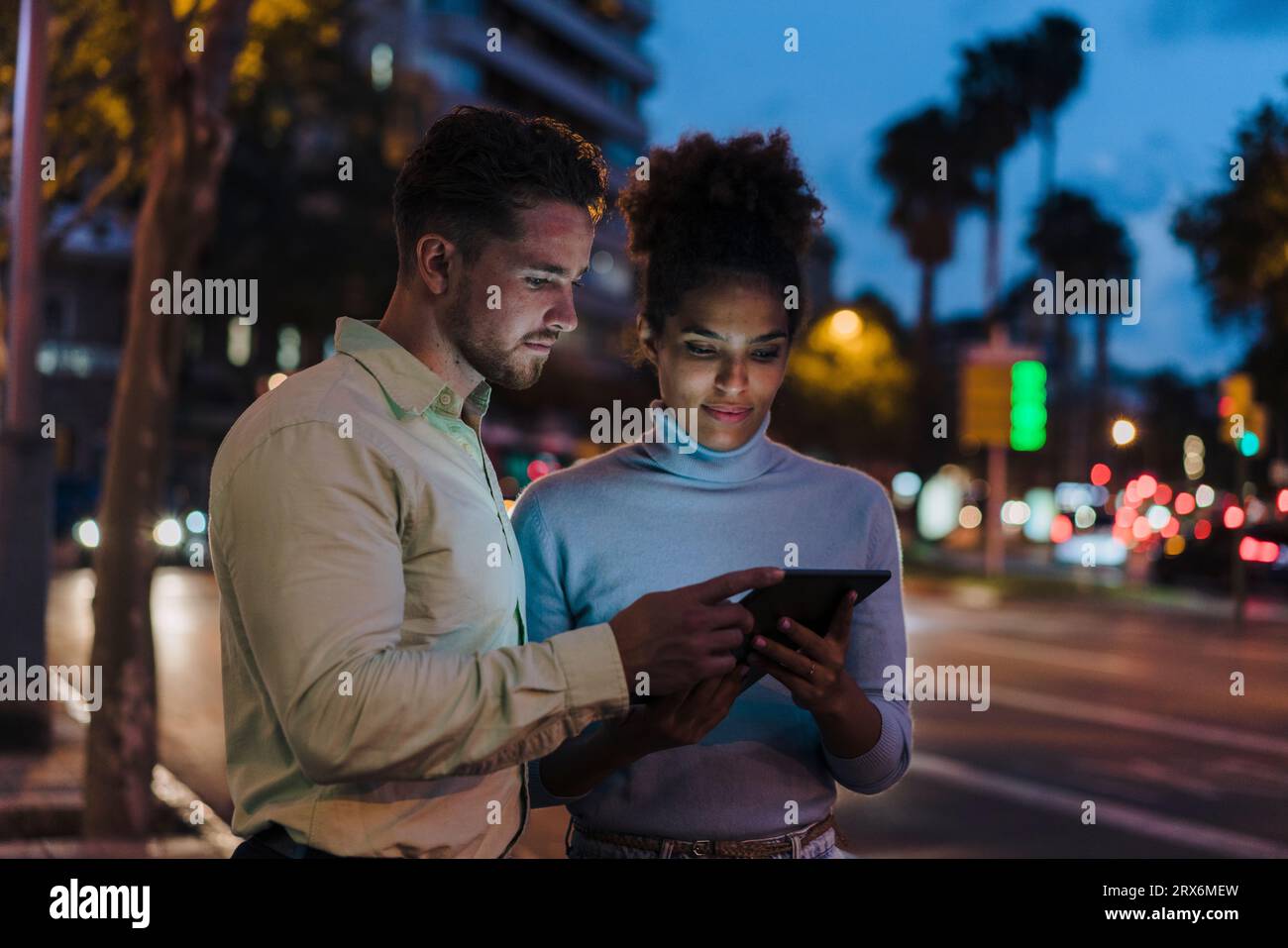 Gli uomini d'affari discutono al crepuscolo su un tablet PC Foto Stock